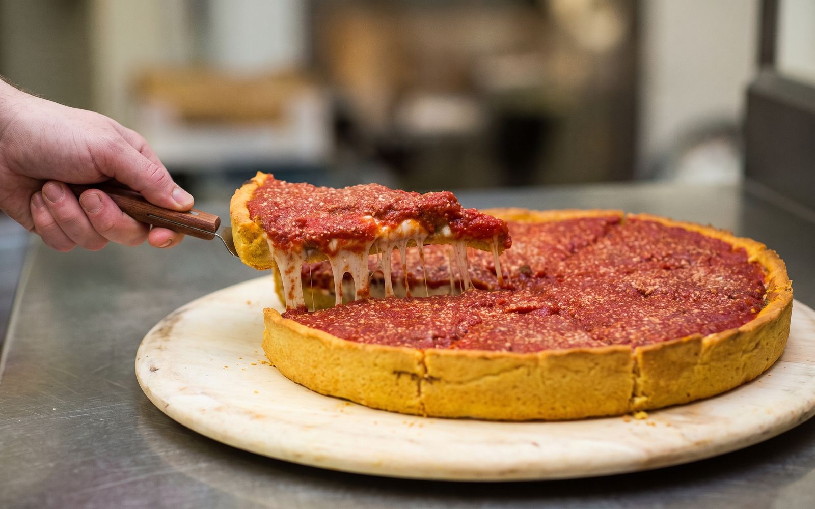 A slice being lifted from a Chicago-style deep dish pizza