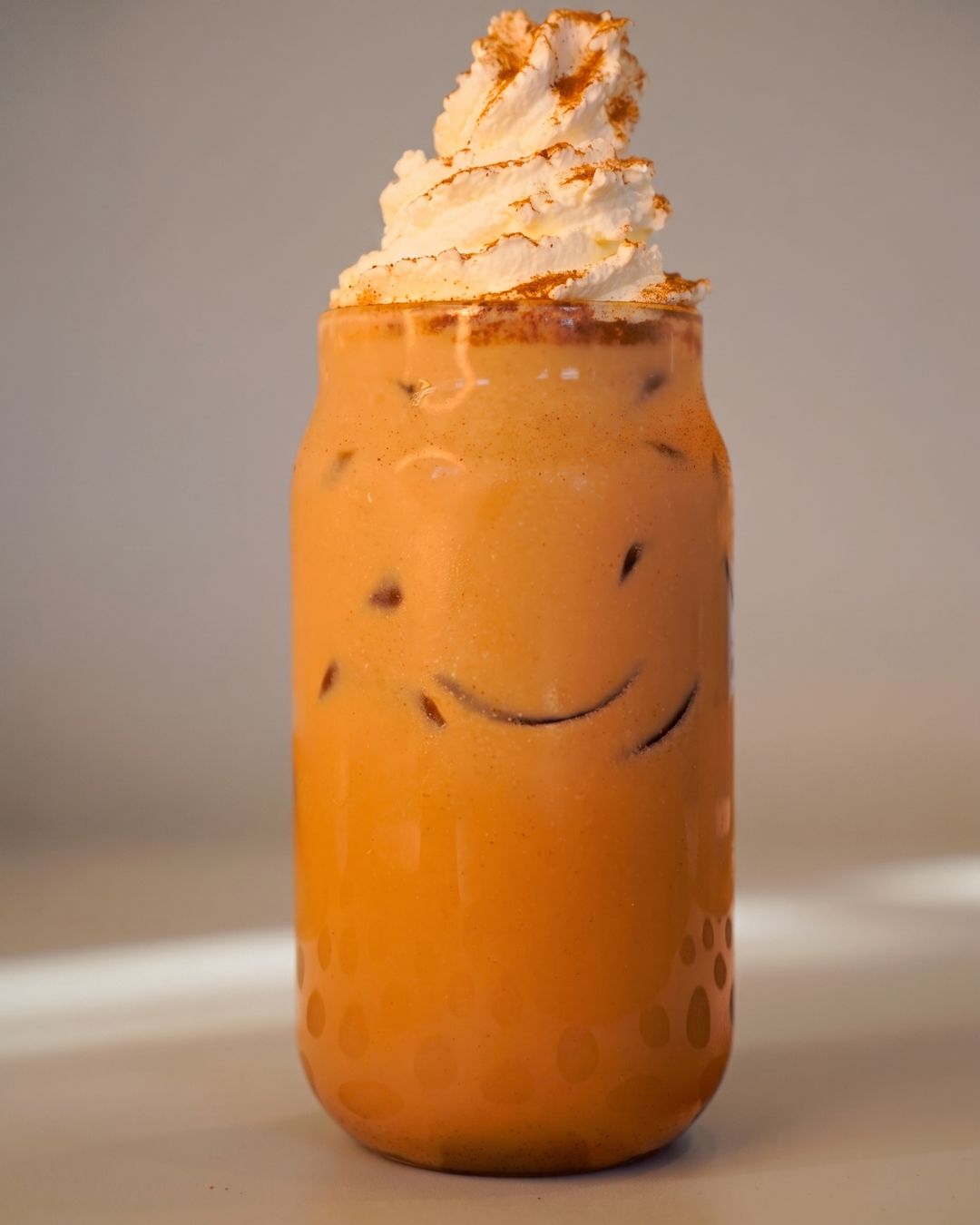 Iced horchata latte topped with whipped cream and cinnamon