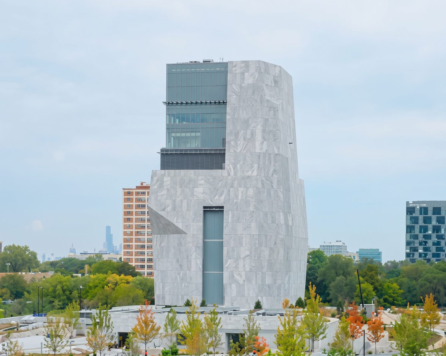 The Obama Presidential Center tower above its landscaped grounds in Jackson Park, the Chicago skyline beyond