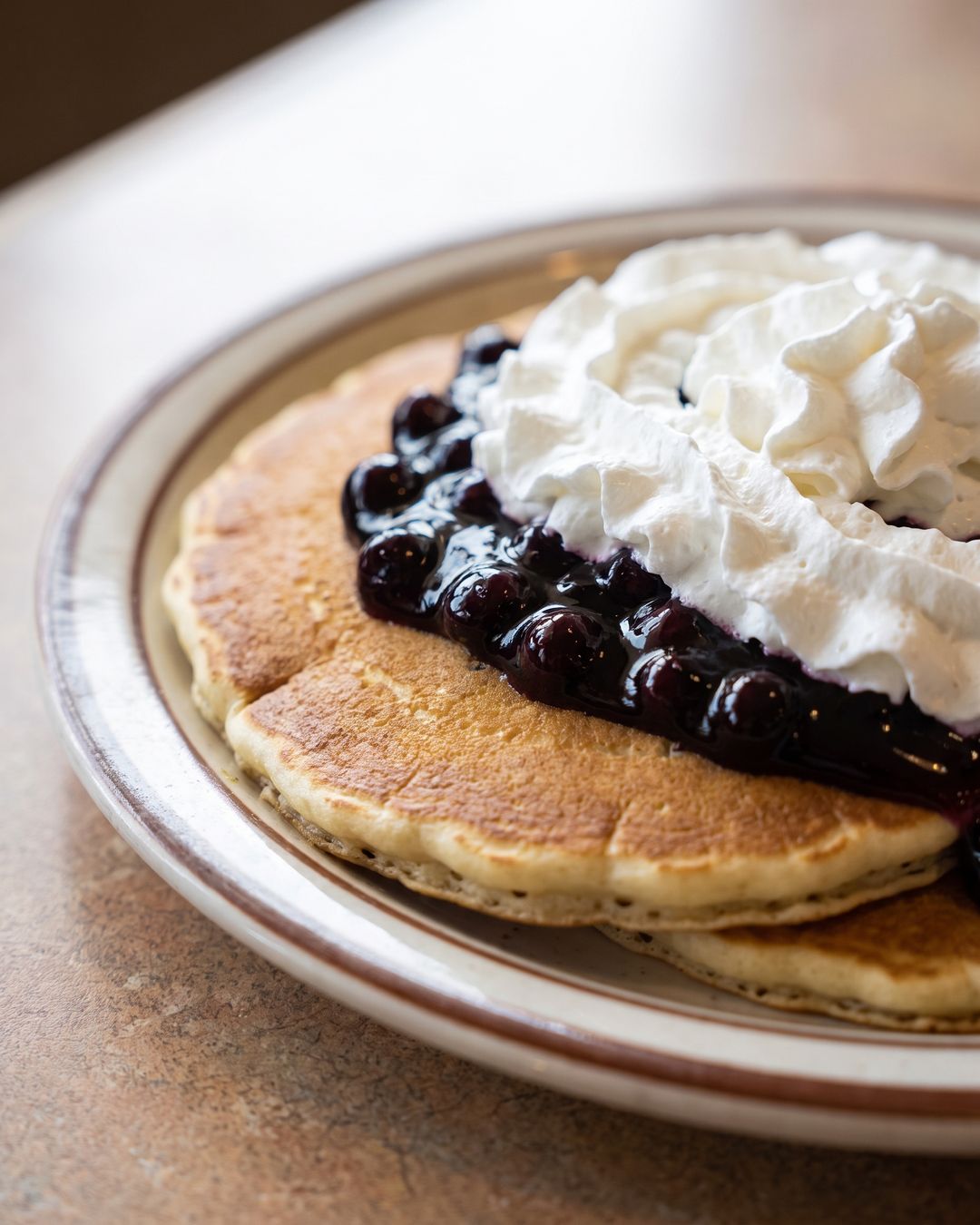 Blueberry pancakes topped with whipped cream