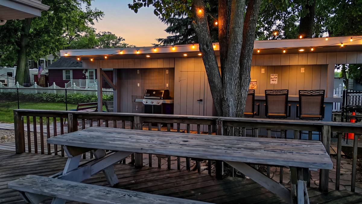 The backyard bar at twilight, string lights and bar lights glowing