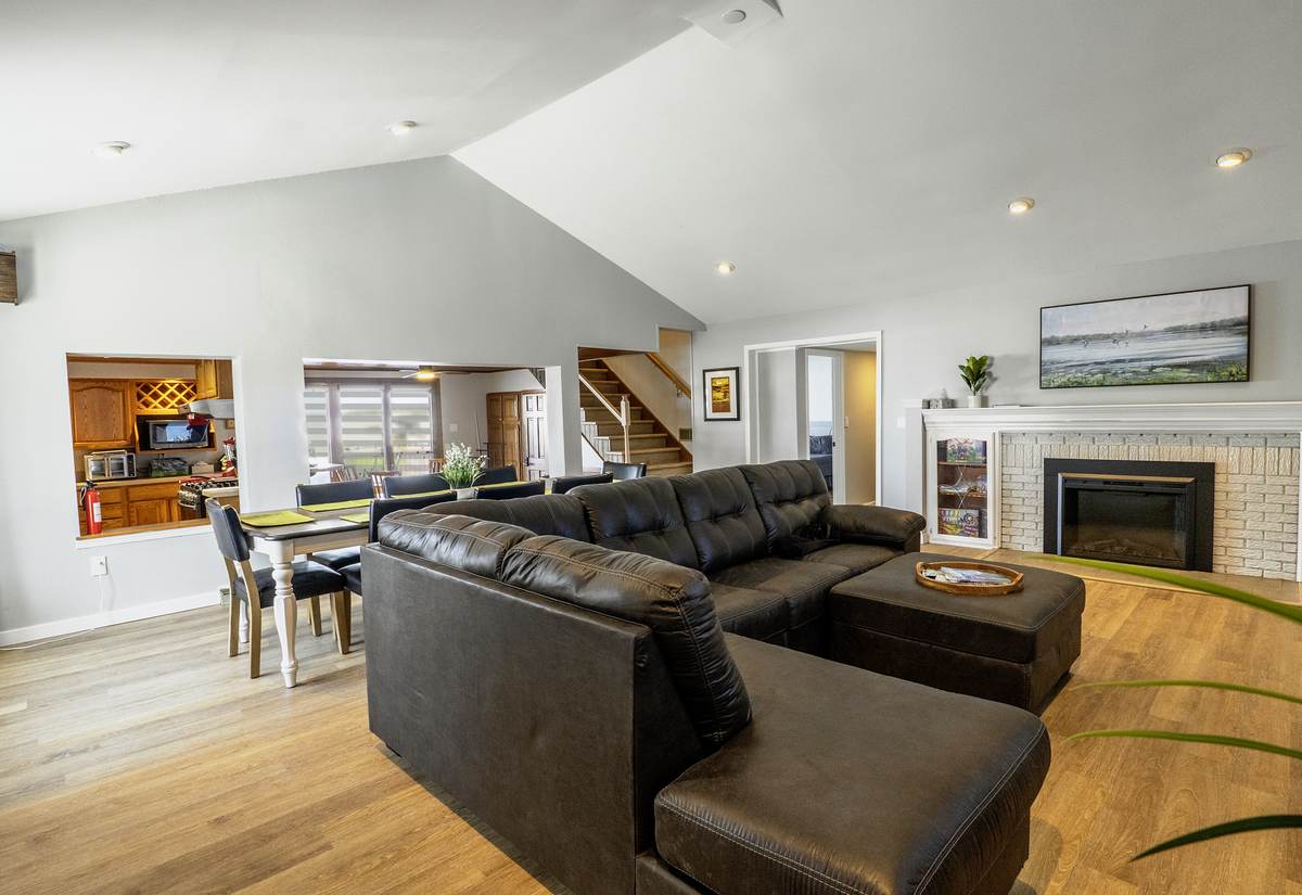 The open main floor from the front door — sectional, dining, kitchen