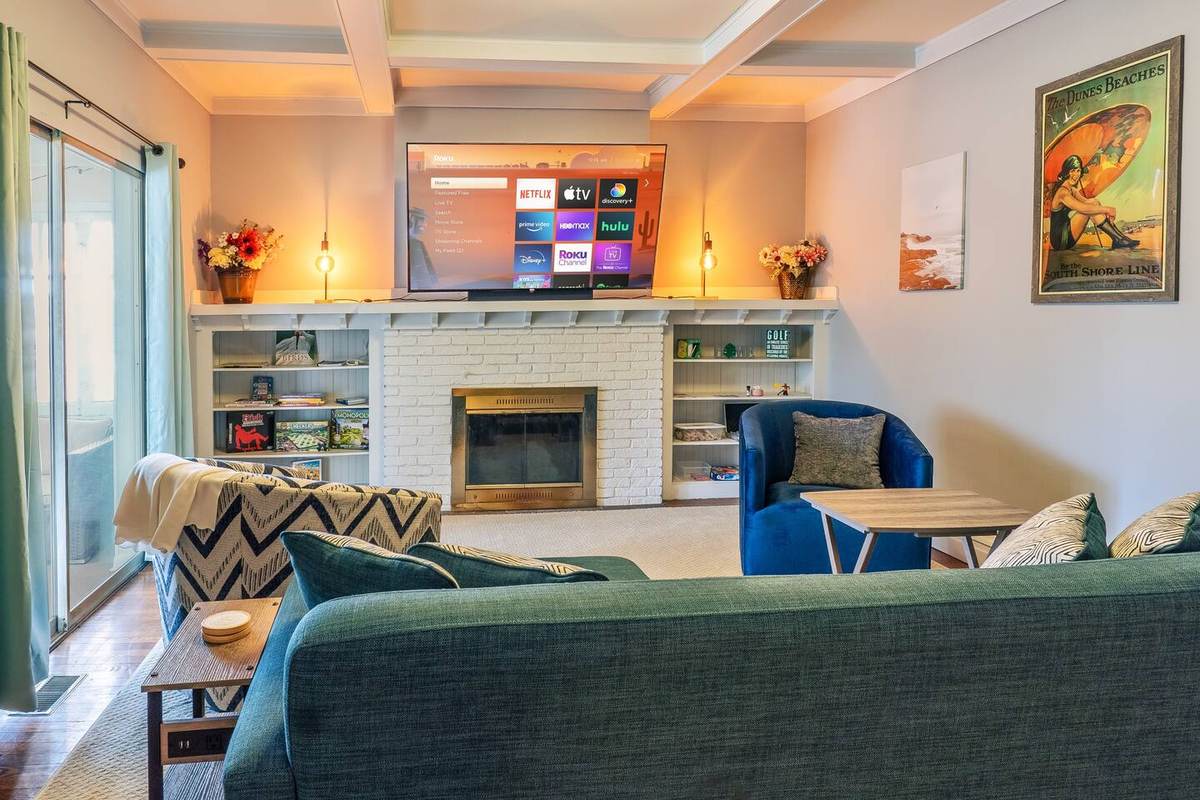 Living room — sofa, swivel chairs, and the 70-inch Roku TV